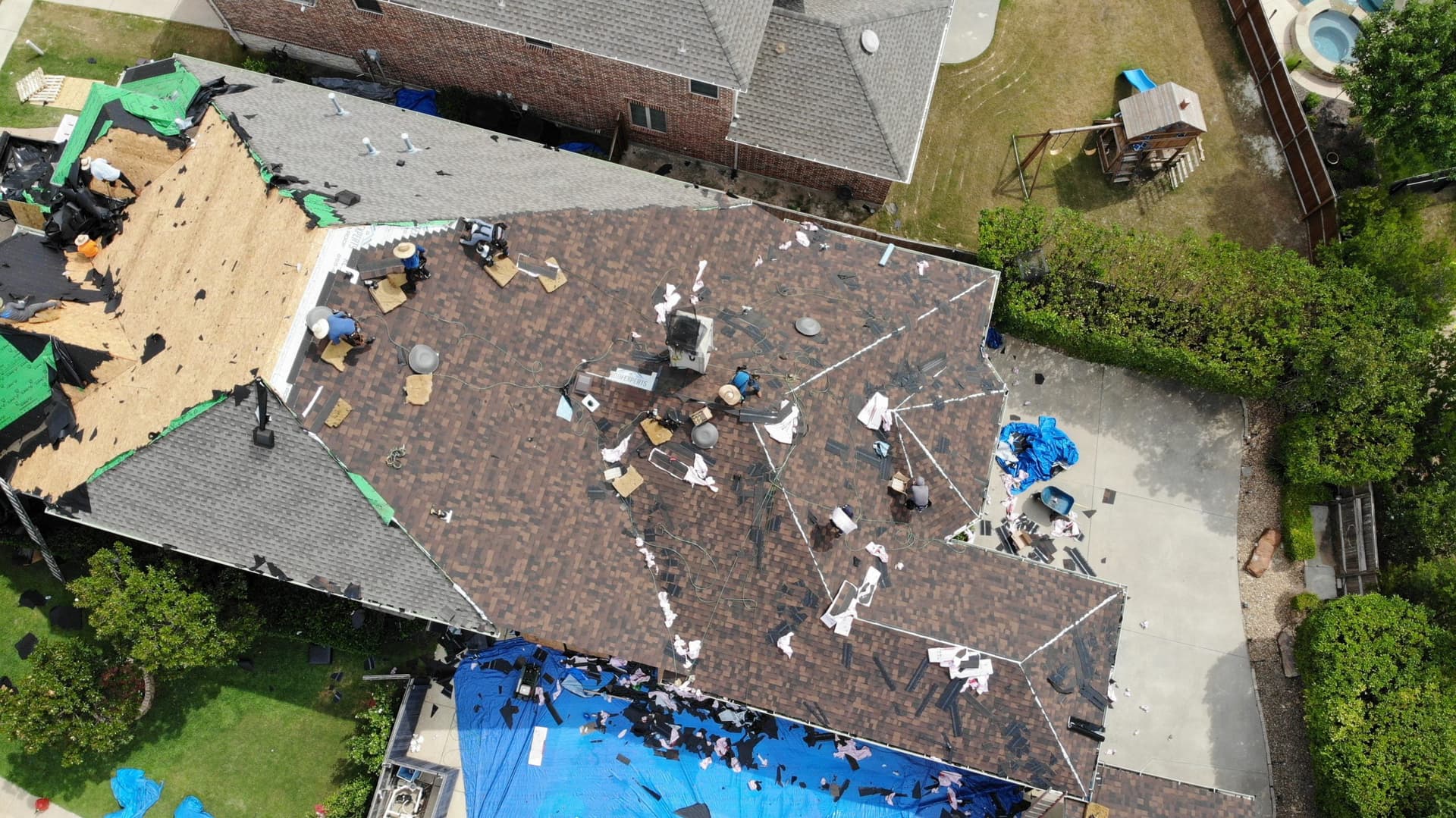 Roof strip-out underway with ground protection and debris containment